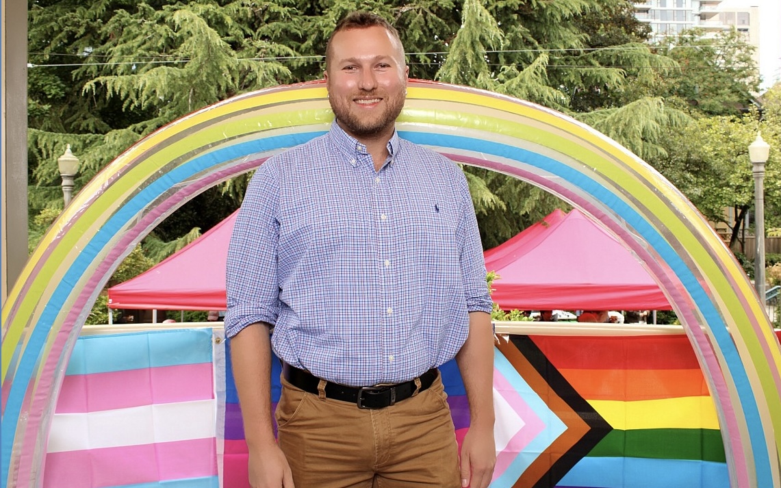 Ryan Stillwagon standing in front of a rainbow installation